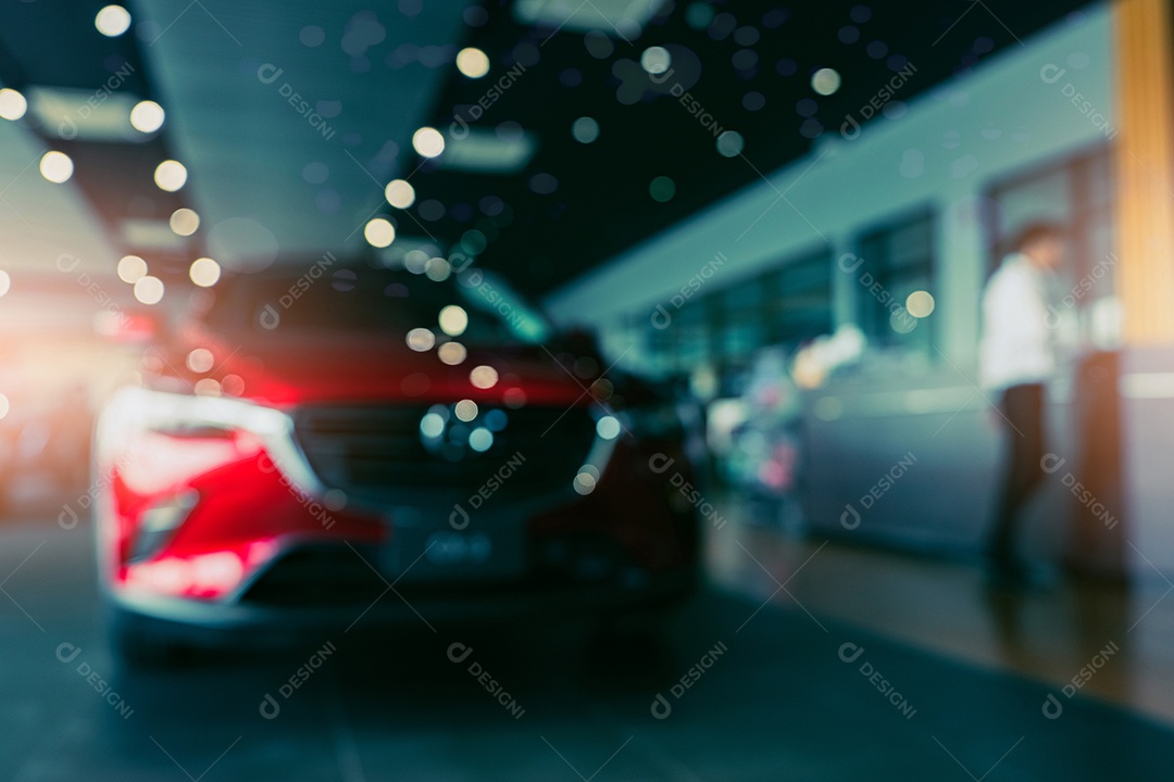 Foto desfocada novo carro vermelho estacionado no showroom. Concessionária de carros desligada