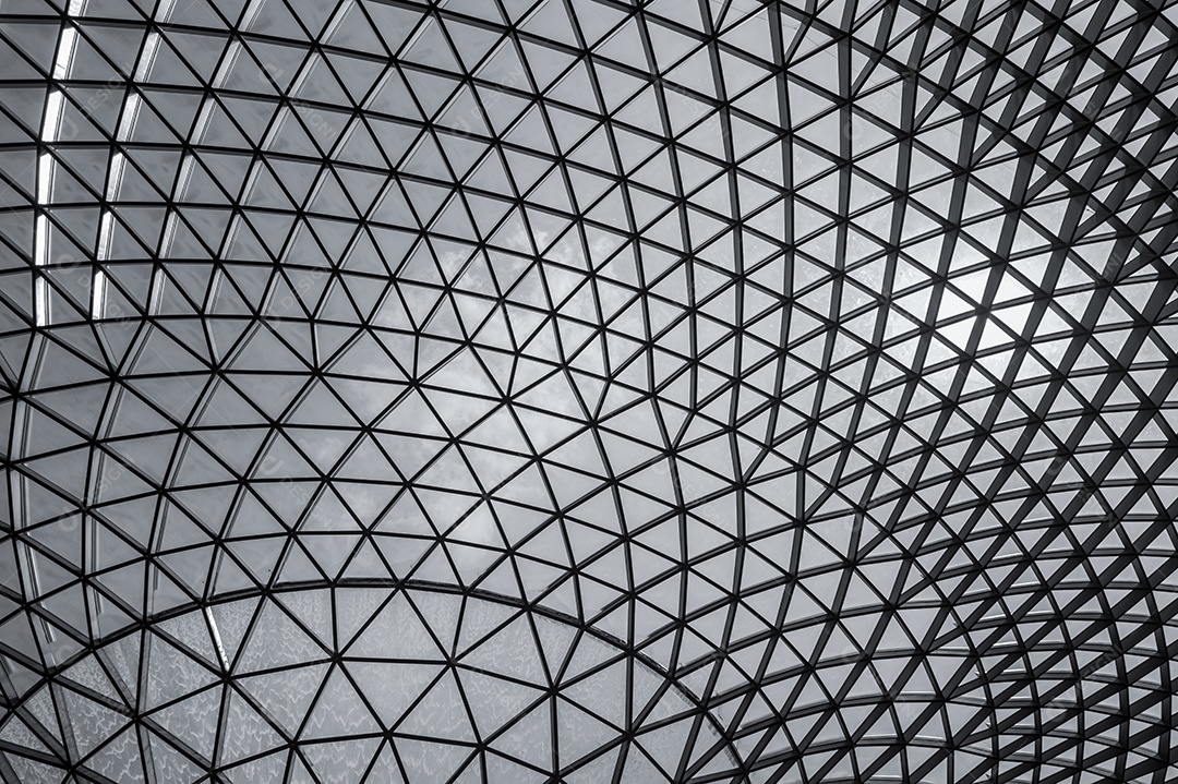 Edifício de vidro e aço com estrutura de padrão triangular.