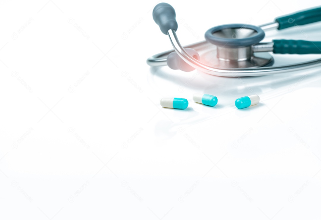 Estetoscópio e pílulas de cápsula azul-branca na mesa do médico ou enfermeiras