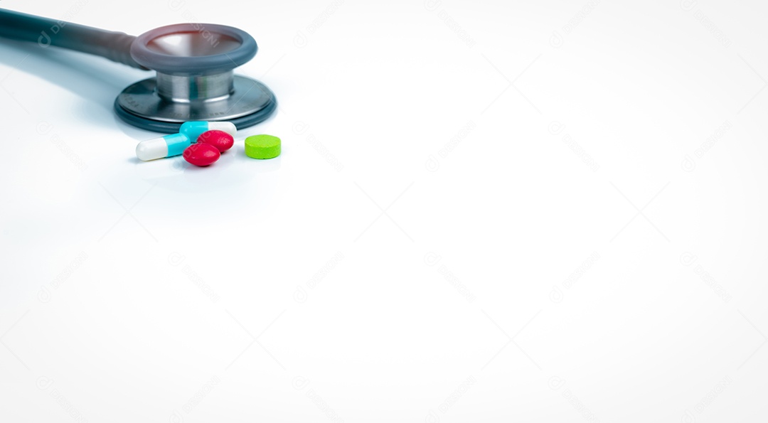 Estetoscópio e pílulas de cápsula azul-branca na mesa do médico ou enfermeiras