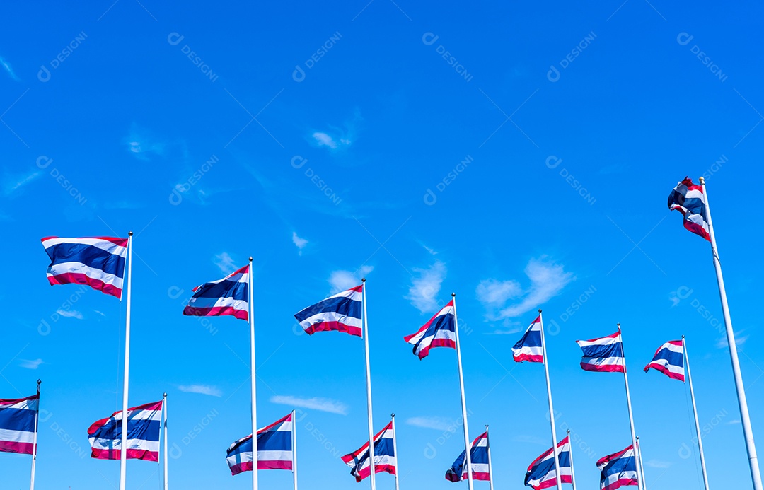 Muitas das bandeiras da Tailândia acenando em cima do mastro contra o céu azul