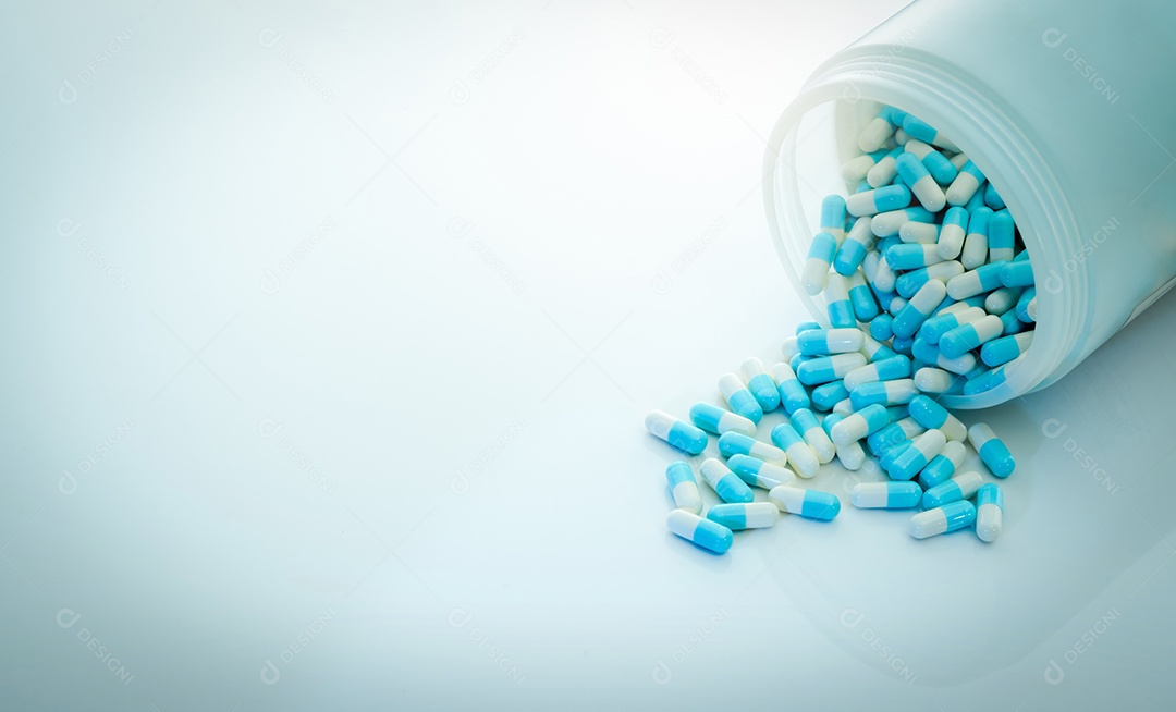 Comprimido de cápsula de antibiótico azul-branco e frasco de comprimidos de cápsula.