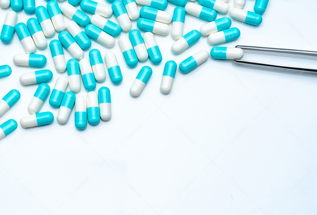 O fórceps escolhe a cápsula branco-azul do grupo de comprimidos da cápsula.