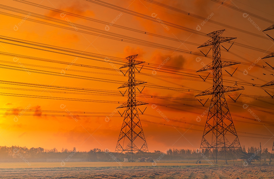 Pilão elétrico de alta tensão e fio elétrico com céu pôr do so