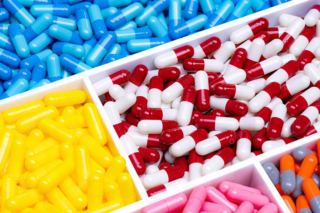 Vista superior de cápsulas coloridas em bandeja de plástico.