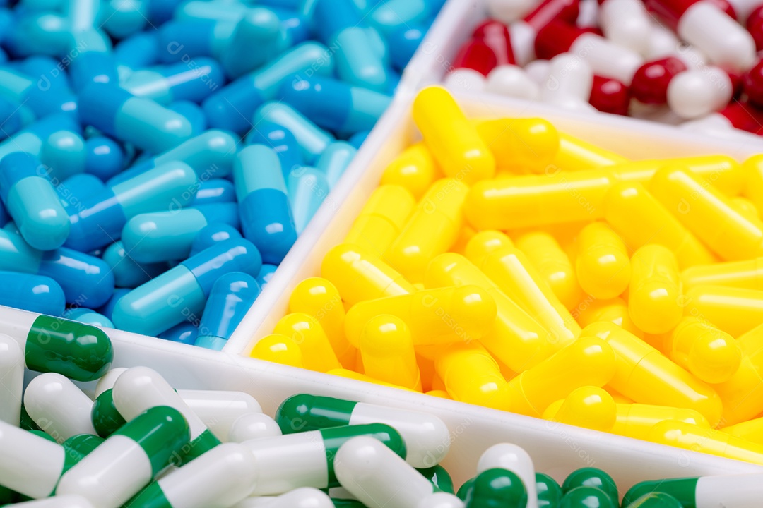 Foco seletivo em pílulas de cápsula verde-brancas em amarelo turvo