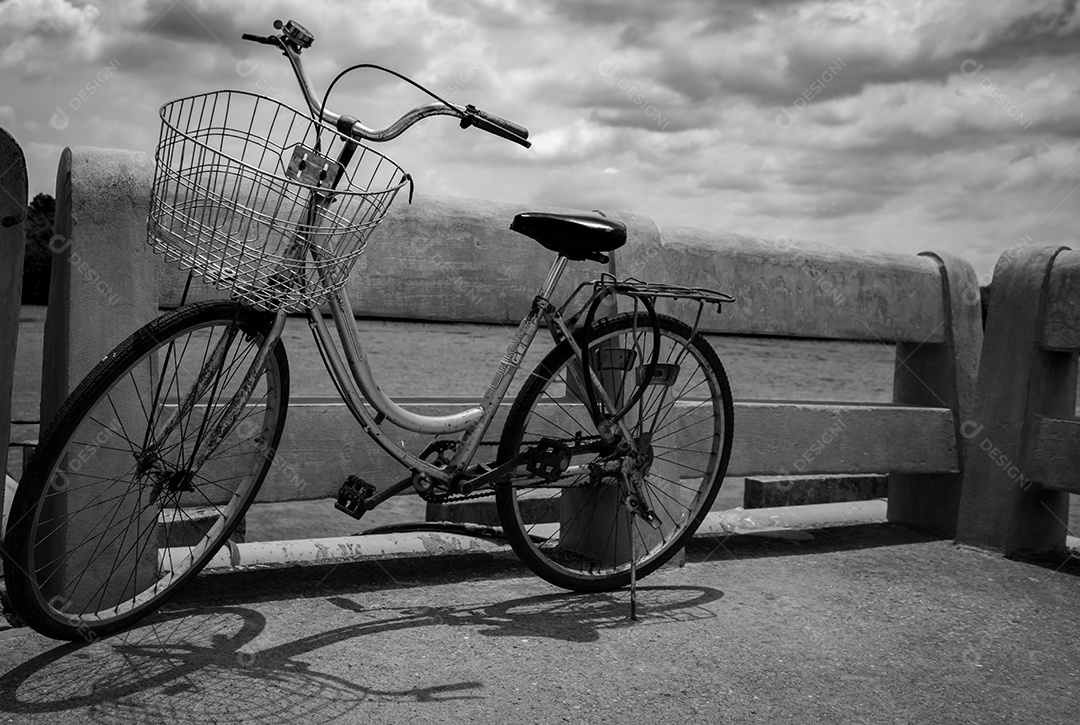 Vintage bicicleta solitária estacionada na estrada de concreto à beira do rio