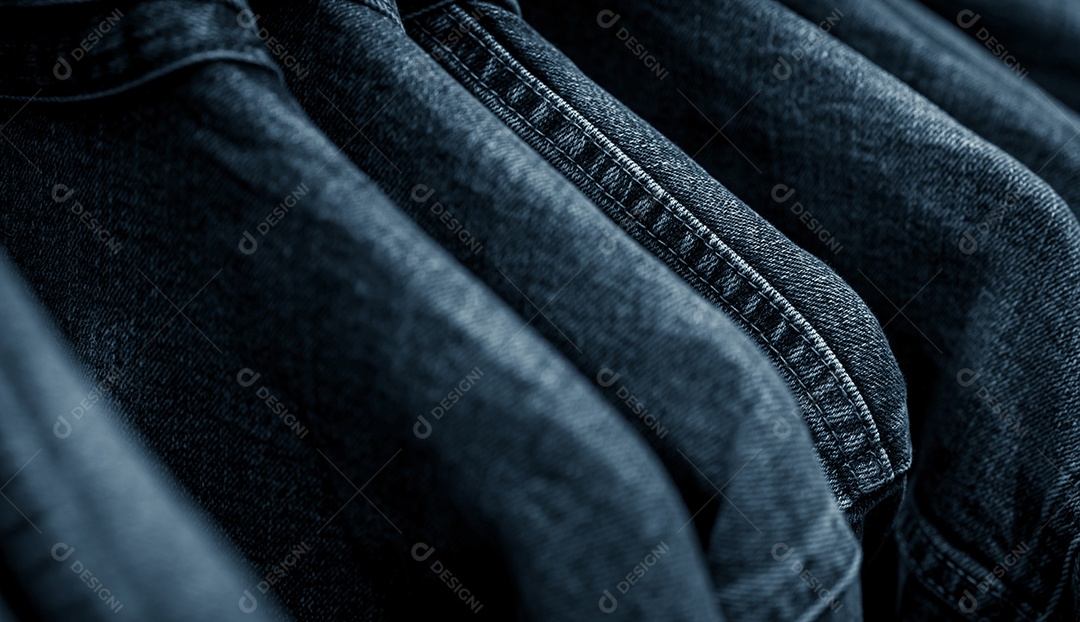 Foco seletivo na jaqueta jeans pendurada no cabideiro na loja de roupas.