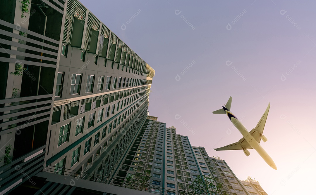 Avião voando acima do prédio de apartamentos moderno.