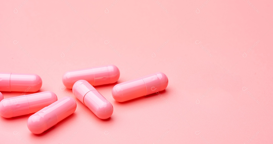 Pílula de cápsulas rosa em fundo rosa. Vitaminas e suplementos.