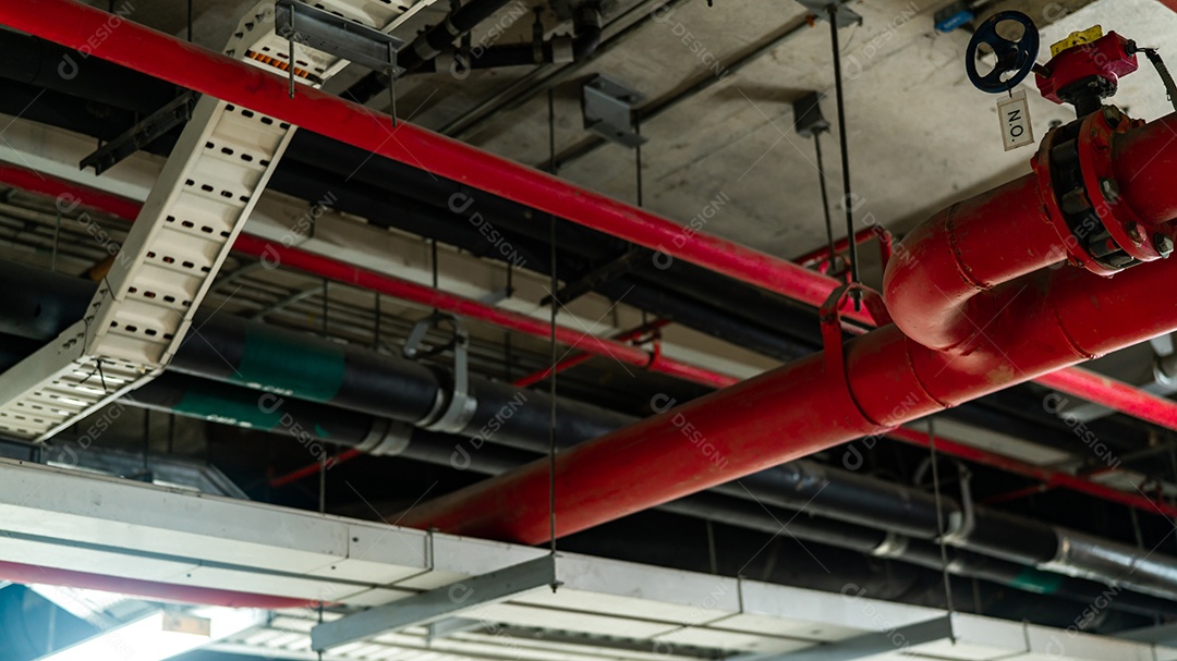 Sistema de aspersão de incêndio com tubos vermelhos pendurados no teto dentro