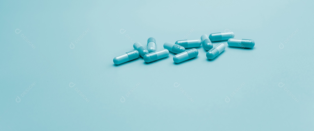 Comprimidos de cápsula de antibiótico azul sobre fundo azul pastel. Farmacêutico