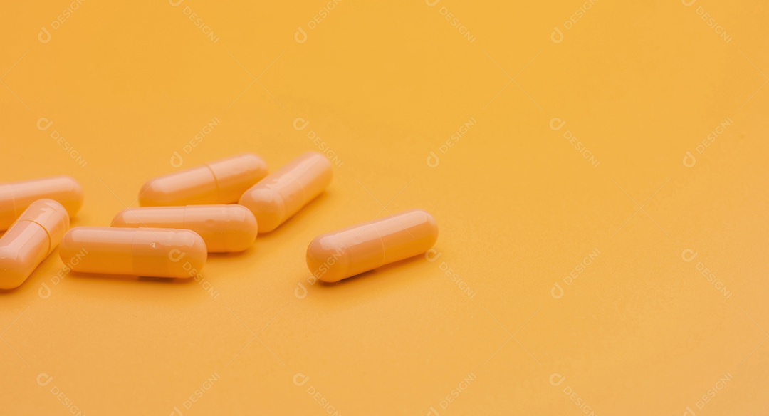 Comprimidos amarelos da cápsula no fundo amarelo com espaço da cópia.