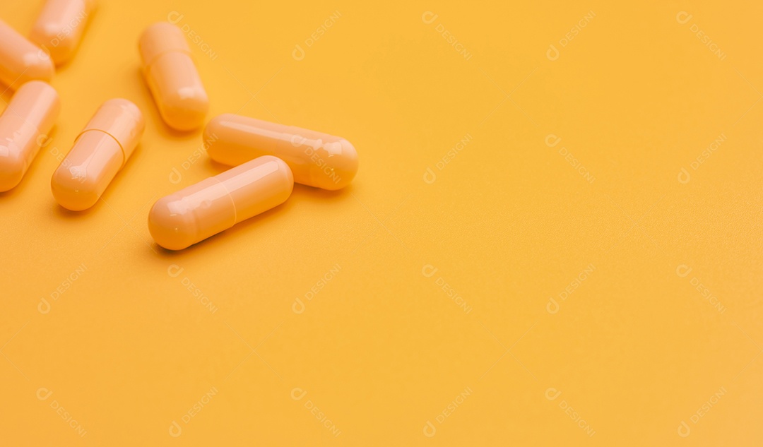 Comprimidos amarelos da cápsula no fundo amarelo com espaço.