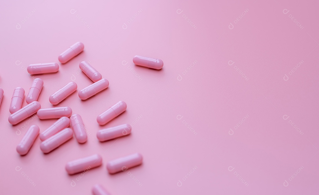 Pílula de cápsulas rosa em fundo rosa. Vitaminas e suplementos.