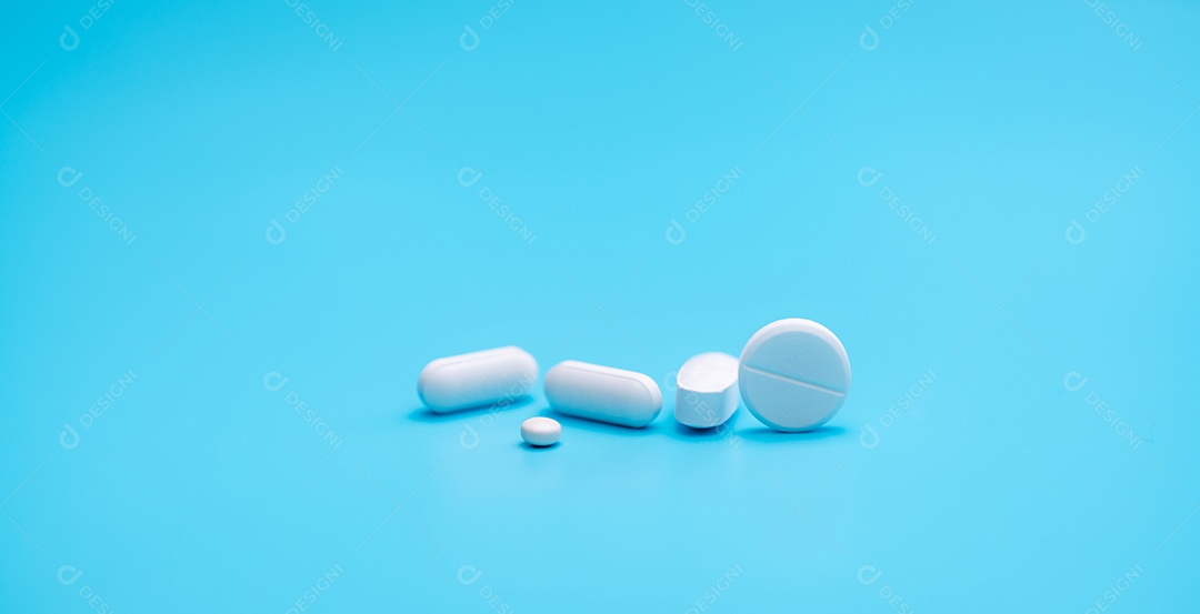 Pílulas de comprimidos redondos brancos sobre fundo azul. Comprimidos e cápsulas