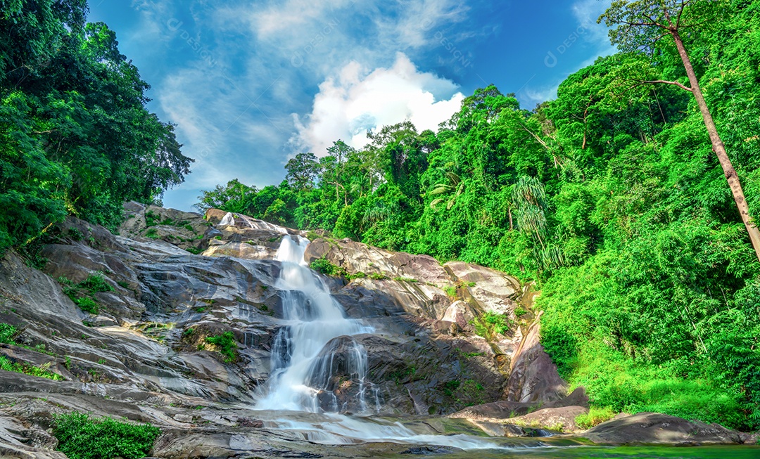 Cachoeira bonita na montanha com céu azul e cumulus branco