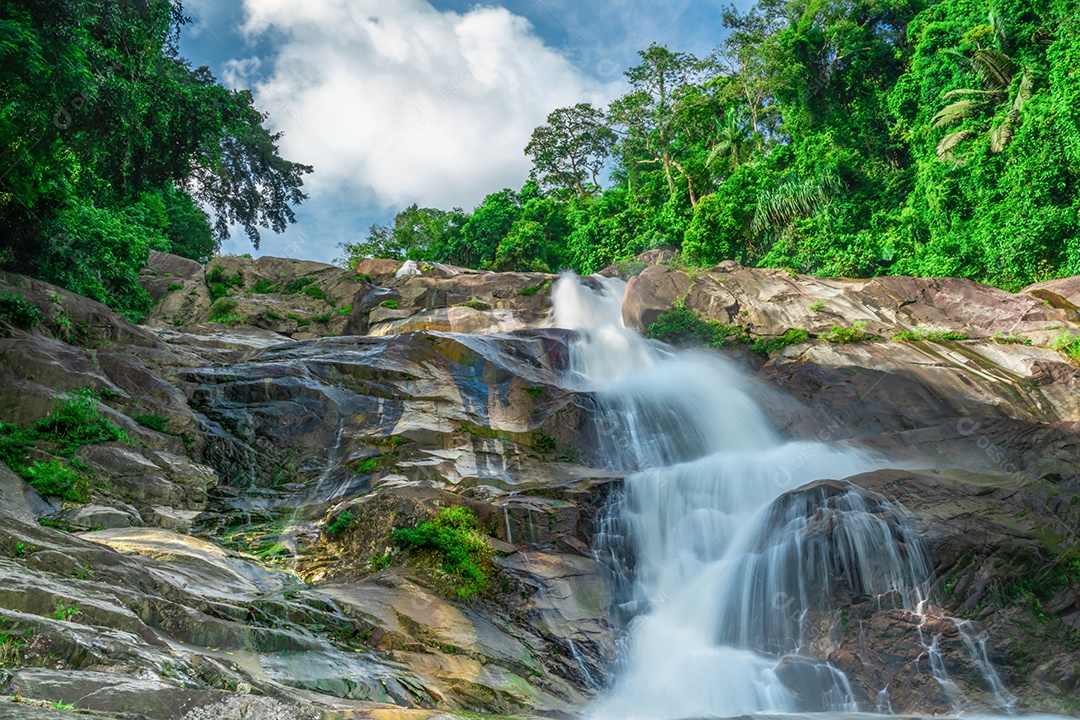 Cachoeira bonita na montanha com céu azul e cumulus branco