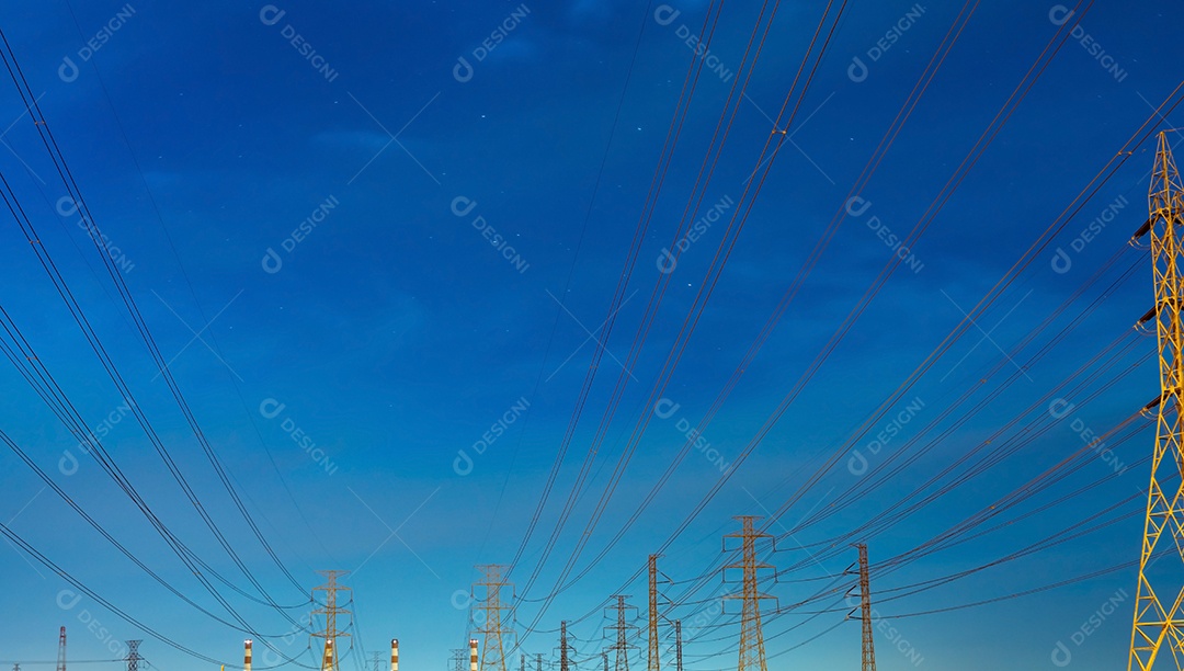 Poste elétrico de alta tensão e linhas de transmissão à noite