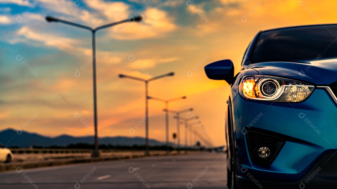 Luz aberta do farol do carro SUV compacto azul estacionada na estrada concreta