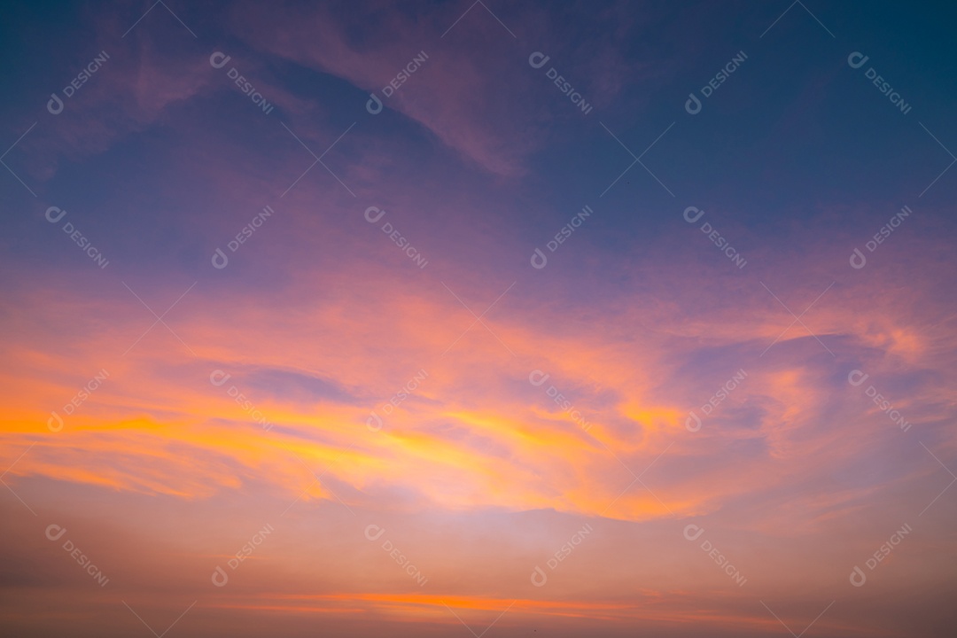 O céu alaranjado dramático e as nuvens abstraem o fundo.