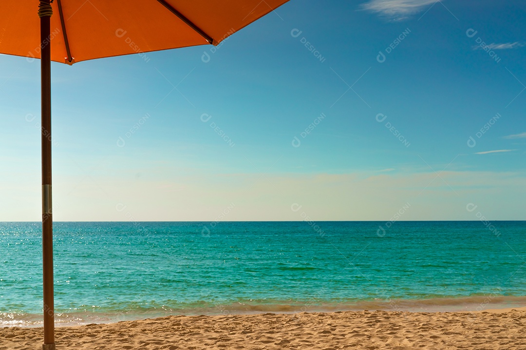 Guarda-sol laranja na praia de areia dourada à beira-mar