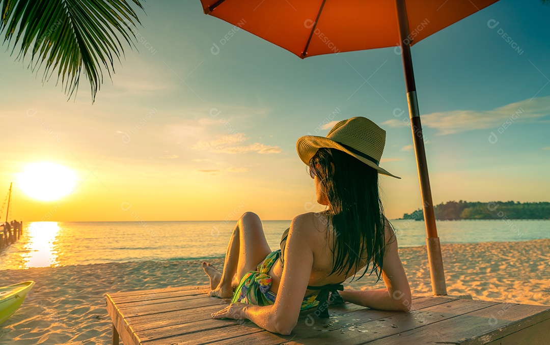 Sexy, aproveite e relaxe mulher usando biquíni deitada e tomando banho de sol