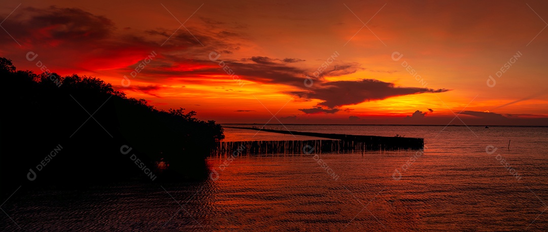 Lindo céu pôr do sol vermelho e laranja sobre o mar tropical.