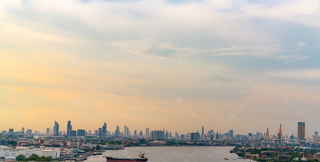 Paisagem urbana de edifício moderno e rio com céu azul e laranja.