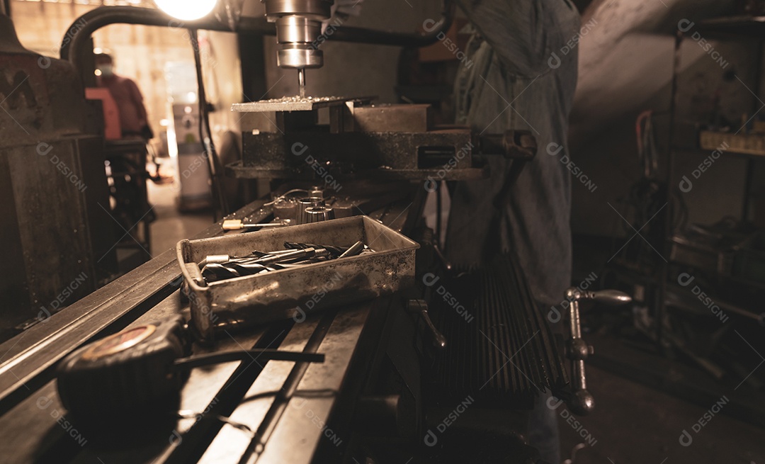 Ferramentas em caixa de plástico na fresadora desfocada e trabalhador em obras