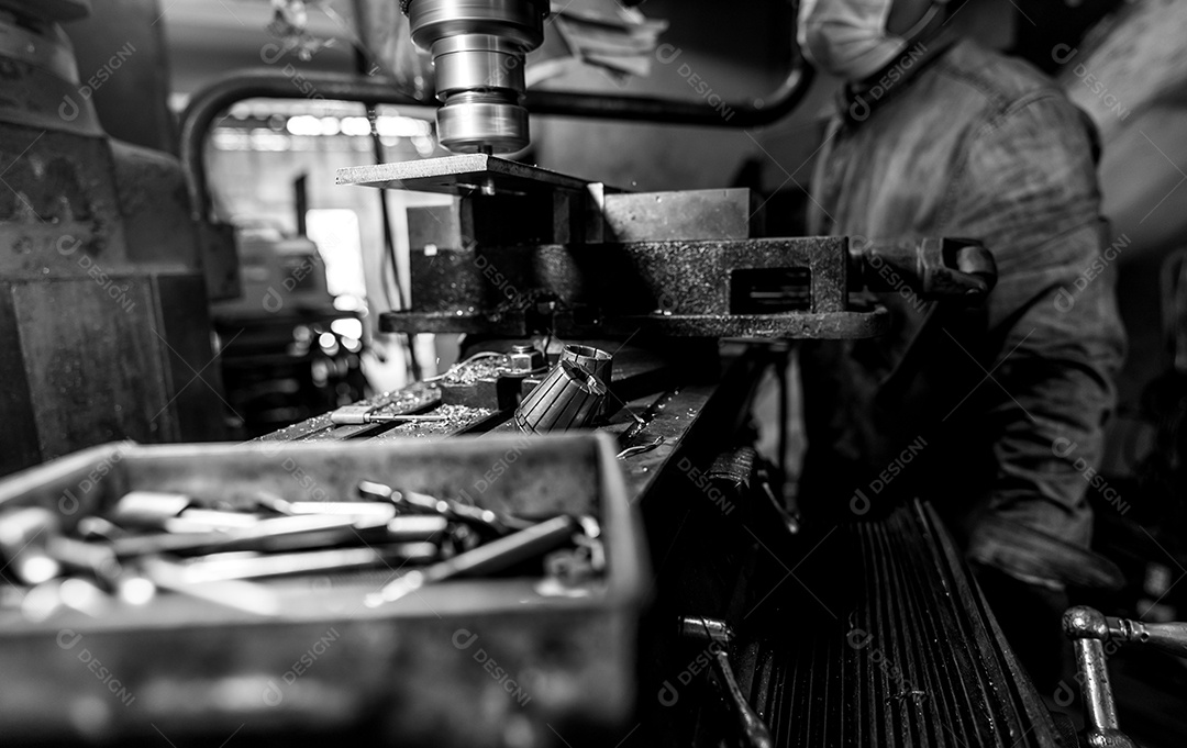 Fresadora trabalhando perto de trabalhador com máscara de proteção.