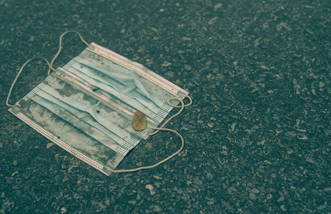Descarte de máscara facial médica usada no chão. Eliminação de resíduos médicos