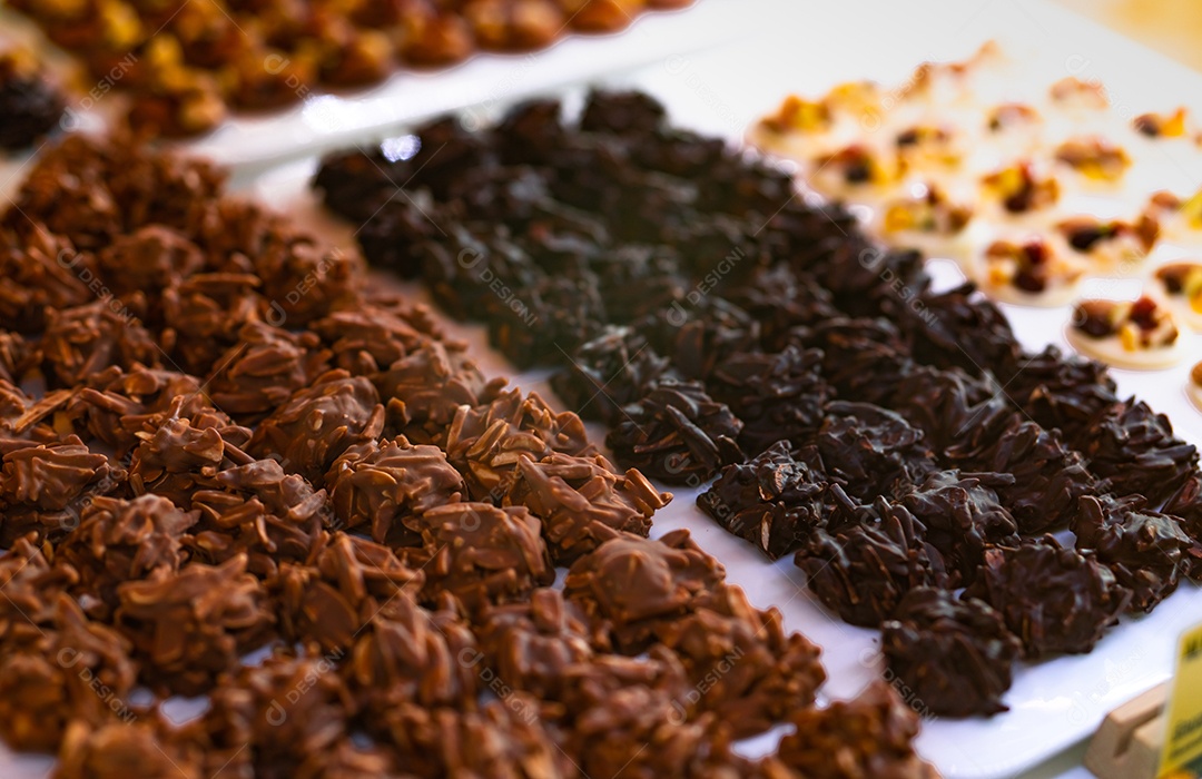 Chocolate amargo revestido de amêndoa e chocolate ao leite na chapa branca.