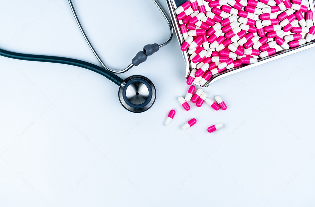 Estetoscópio com pilha de comprimidos de cápsulas de antibióticos em aço inoxidável