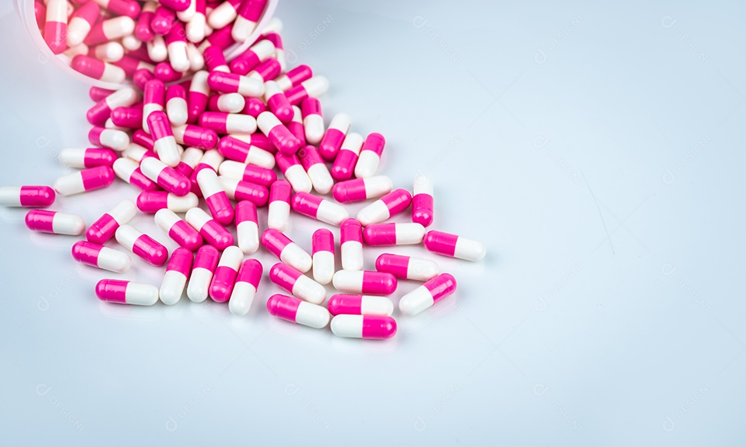 Comprimido de cápsulas rosa e branco derramado de plástico branco