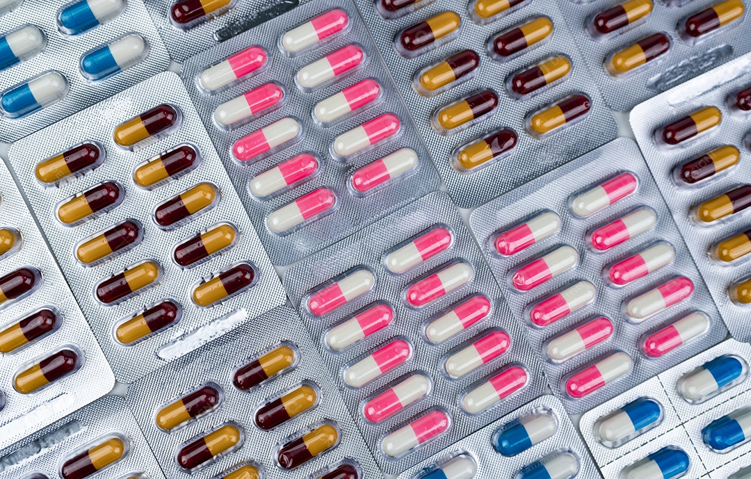 Vista superior de pílulas coloridas de cápsulas de antibióticos em blister