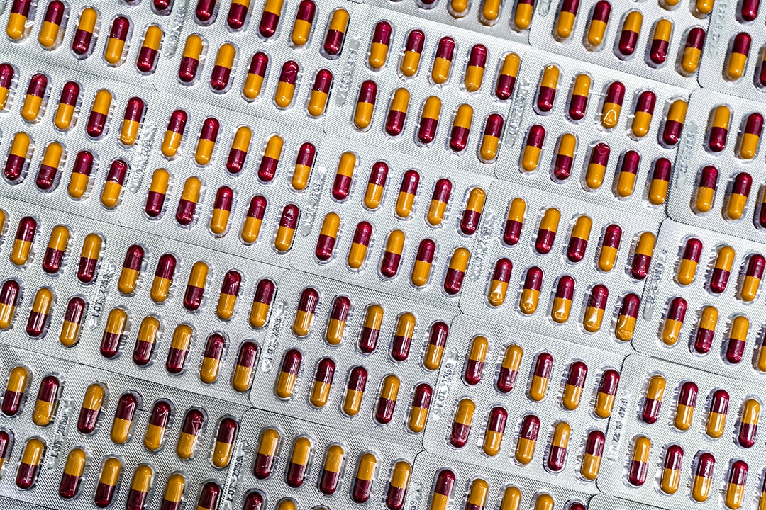 Indústria farmacêutica. Comprimidos de cápsula vermelho-amarelo em blister