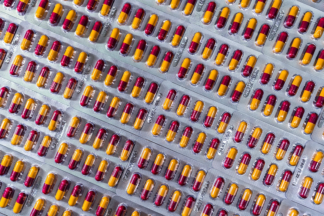 Indústria farmacêutica. Comprimidos de cápsula vermelho-amarelo em blister