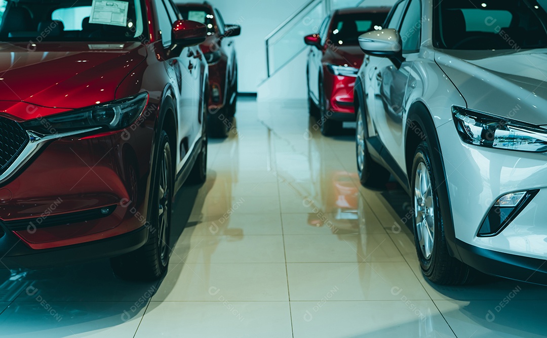 Vista frontal SUV vermelho e carro branco estacionado no showroom de luxo.