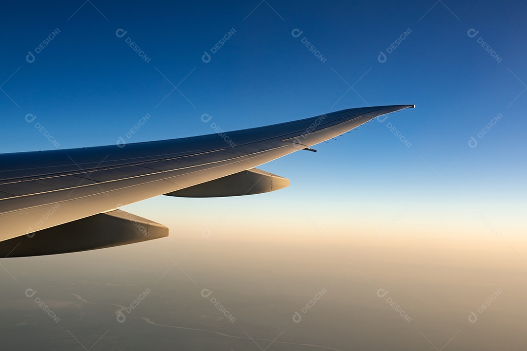Asa de avião sobre a cidade. Avião voando no céu azul.