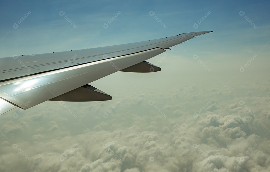 Asa de avião sobre nuvens brancas. Avião voando no céu azul.