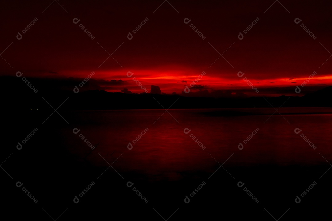 Céu pôr do sol vermelho e laranja na montanha e no lago.