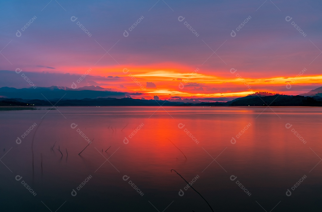 Céu pôr do sol vermelho e laranja na montanha e no lago.