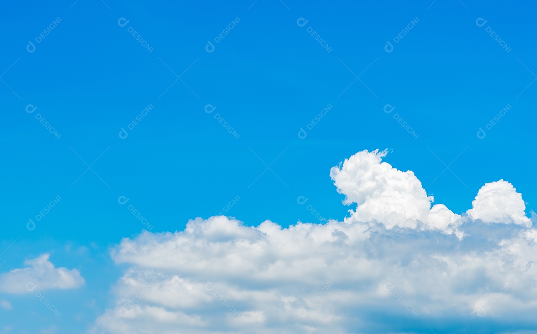 Céu azul e nuvens cumulus brancas sobre a montanha verde.