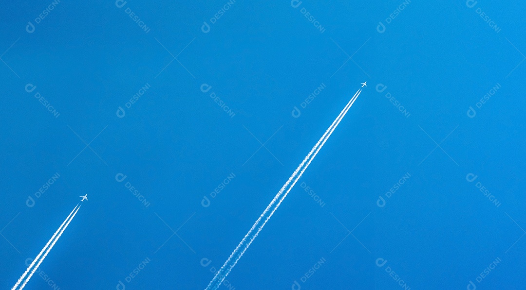 Avião com faixas brancas de condensação. Avião a jato em azul claro