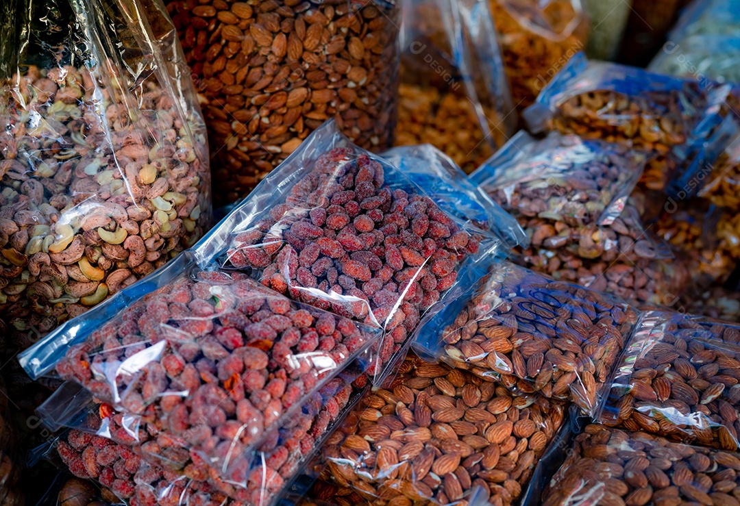 Amêndoas e castanhas de caju em saco plástico no mercado.