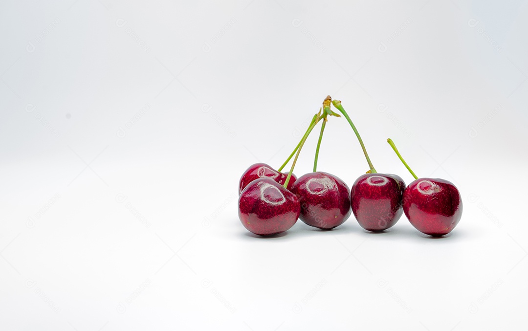 Cereja vermelha com caule e folha isolada no fundo branco.