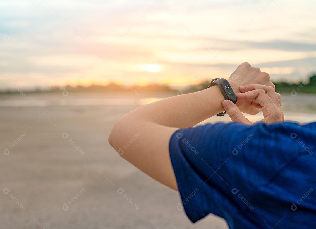 Jovem mulher asiática tocando banda inteligente depois de correr de manhã