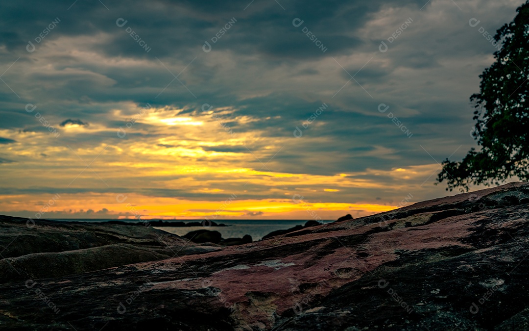 Bela praia de pedra pela manhã com o céu dourado do nascer do sol. Educaçao Fisica