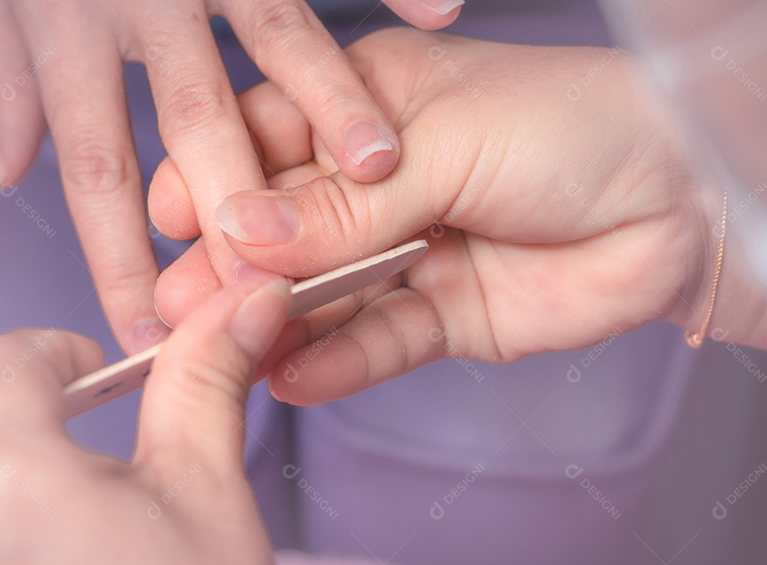 Mulher asiática recebendo serviço de manicure de unha por profissional